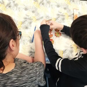 äiti ja lapsi koristelevat yhdessä pipareita
