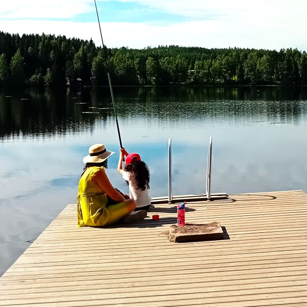 Äiti ja lapsi laiturilla kalastamassa perheleirillä